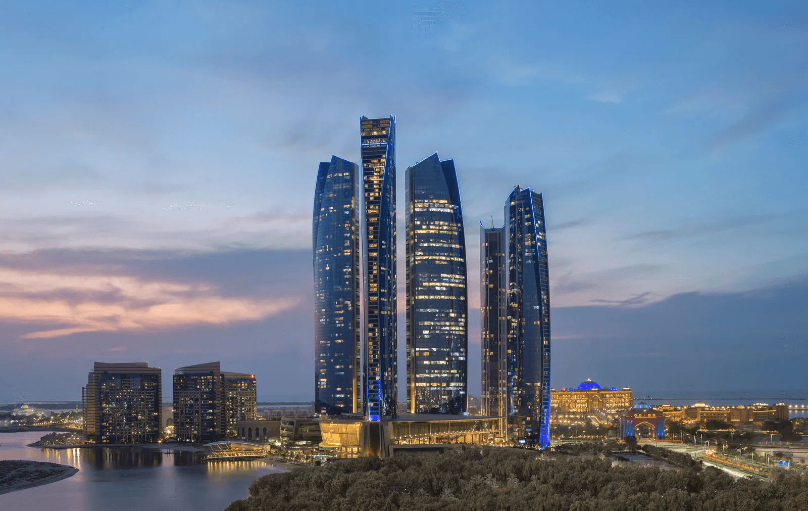 Modern city skyline at dusk with towers reflected on water